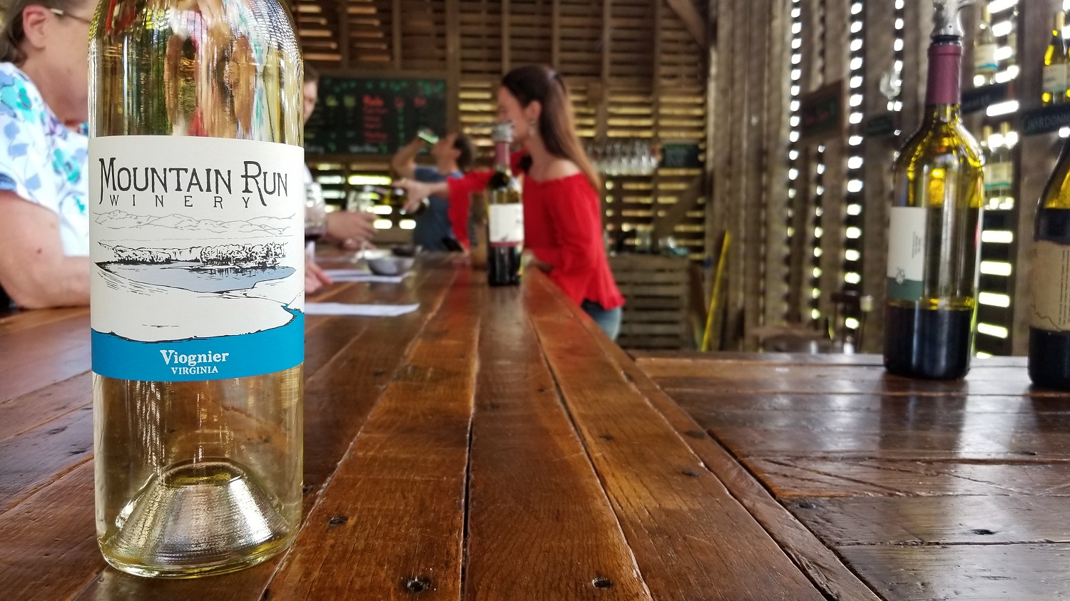 Stephanie in tasting room Bottle of viognier on the bar top
