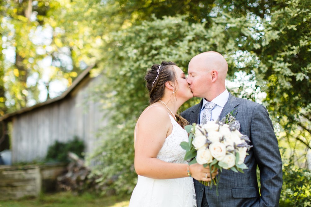 Weddings Wedding Look Book at Mountain Run Winery: Couple kissing in front of old barn