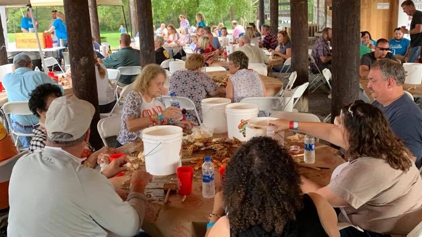 People sitting at a round table eating crabs at Mountain Run Winery crab feast