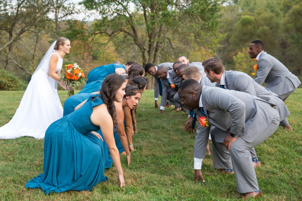 Wedding Look Book at Mountain Run Winery: Bridal party playing football with bouquet