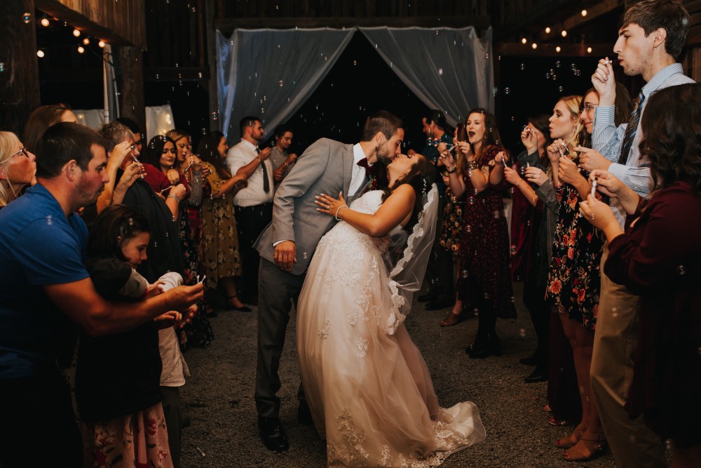 Wedding Look Book at Mountain Run Winery: Couple kissing while bubbles are blown