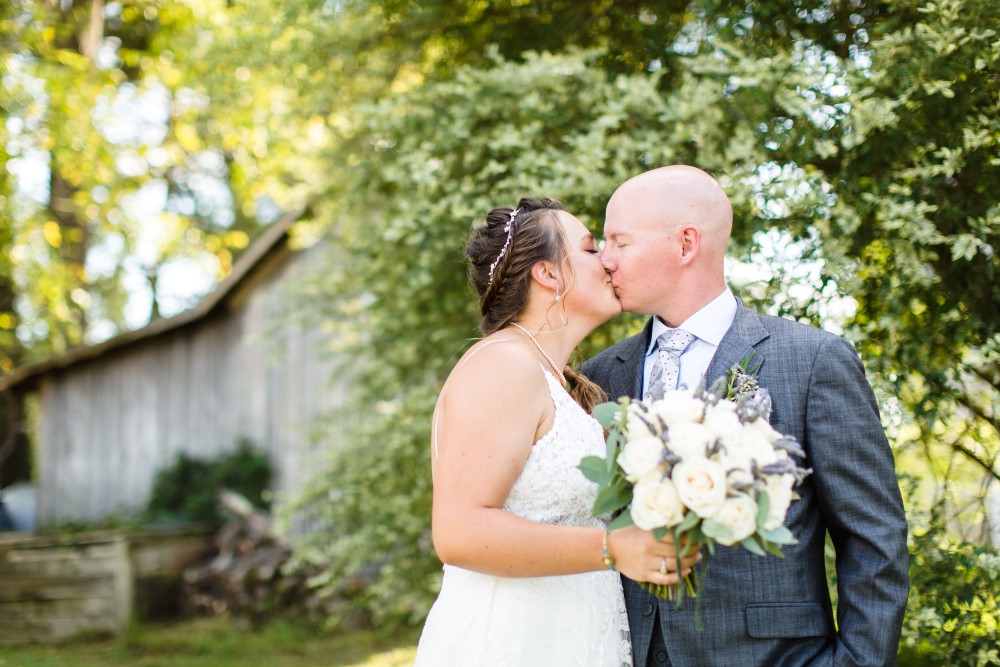 Wedding Look Book at Mountain Run Winery: Couple kissing in front of old barn